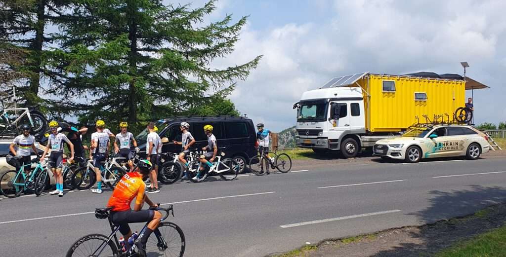 Groep wielrenners naast truck hotel boven op de col, fietsvakantie Pyreneeën